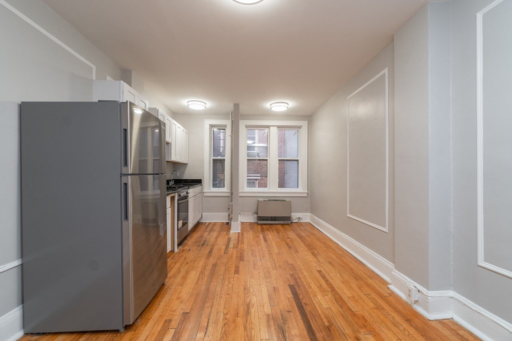 an empty kitchen with stainless steel appliances and a window