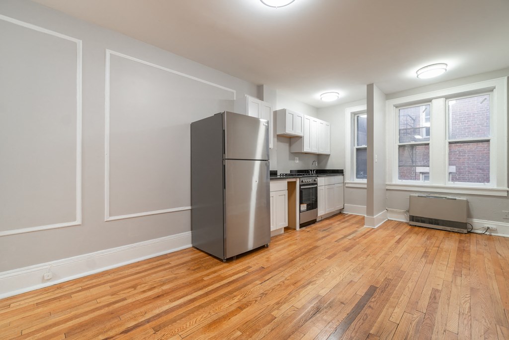 a kitchen with a refrigerator and a stove and a window