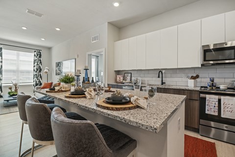 an open kitchen and dining area with a granite counter top