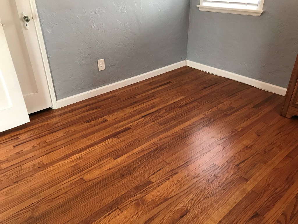 a living room with wooden floors and a gray wall