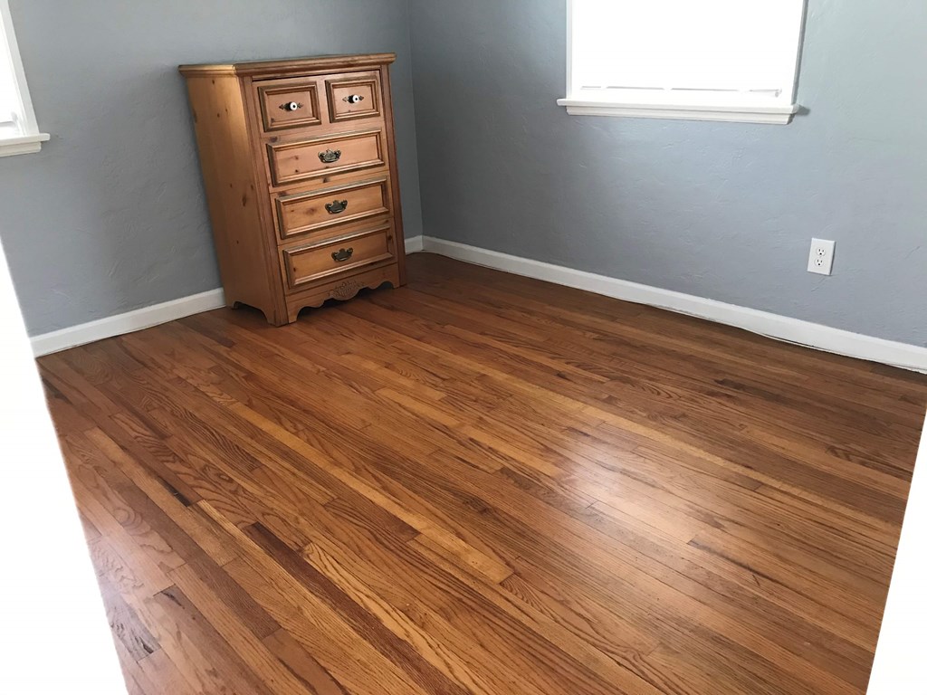 a room with wooden floors and a dresser