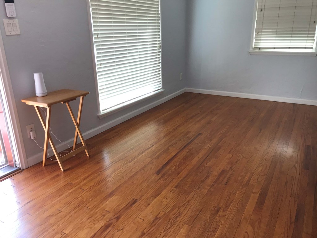 a room with wooden floors and a table in the corner