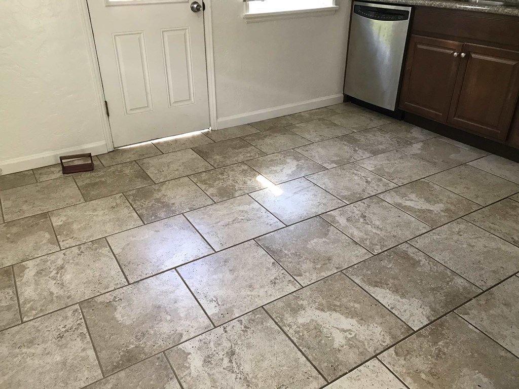 a kitchen with a tiled floor and a refrigerator