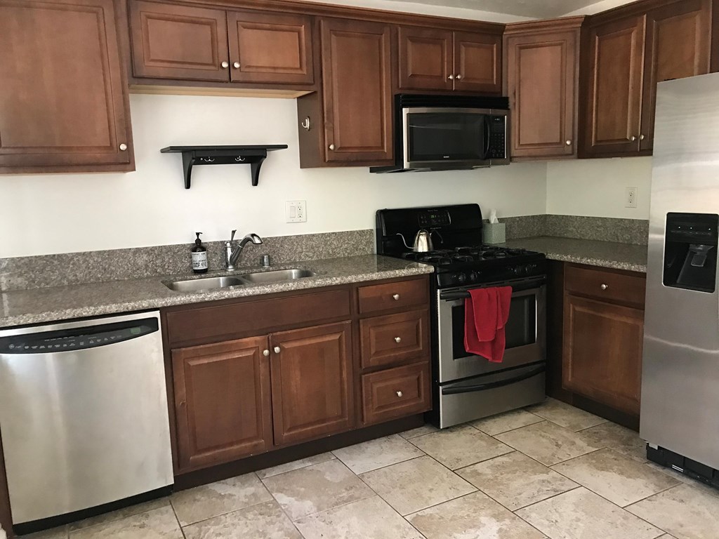 a kitchen with wooden cabinets and stainless steel appliances