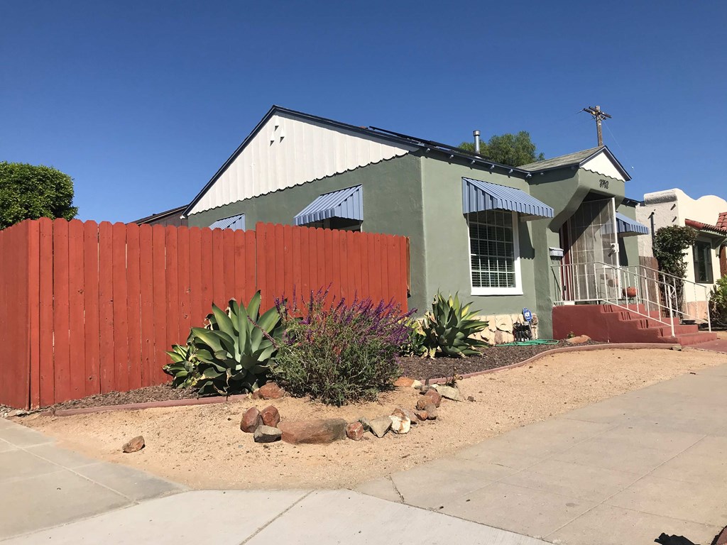 a house with a red fence and a green house