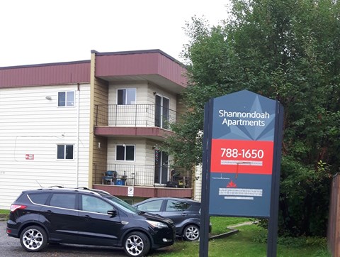 an apartment building with cars parked in front of it