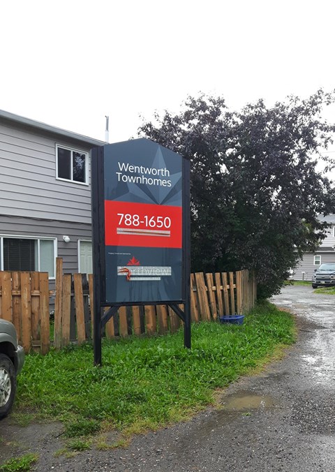 a sign sitting in front of a house