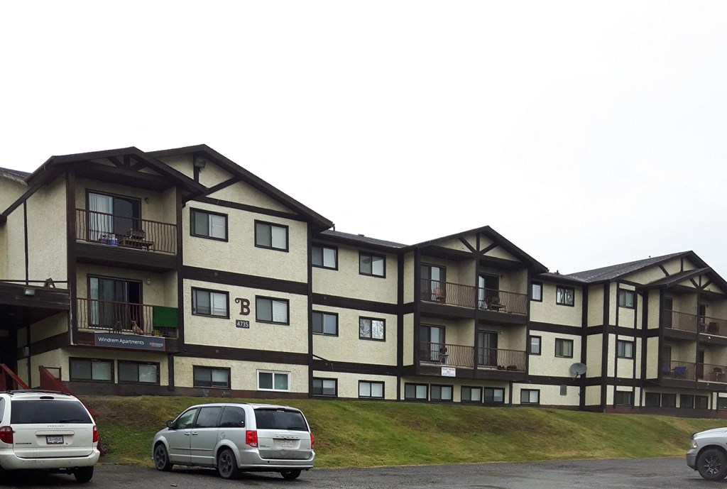 a large apartment building with cars parked in front of it