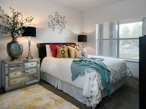 a bedroom with a bed and a vase with flowers