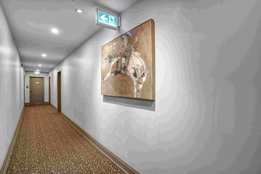 a hallway with a painting of a horse on the wall