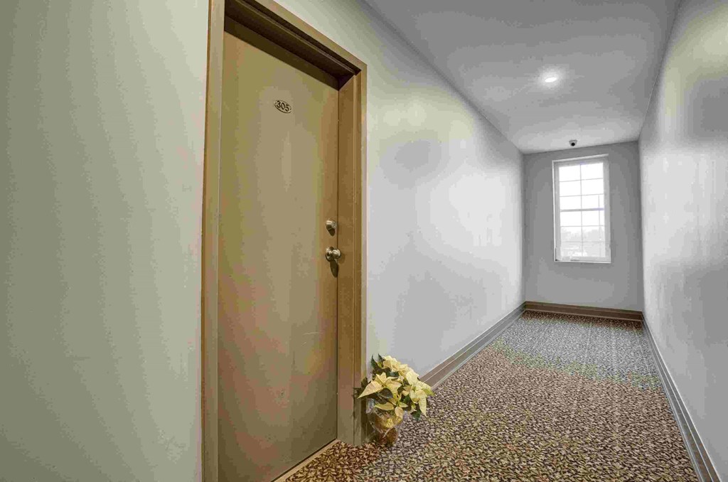 an empty room with a door and a bouquet of flowers