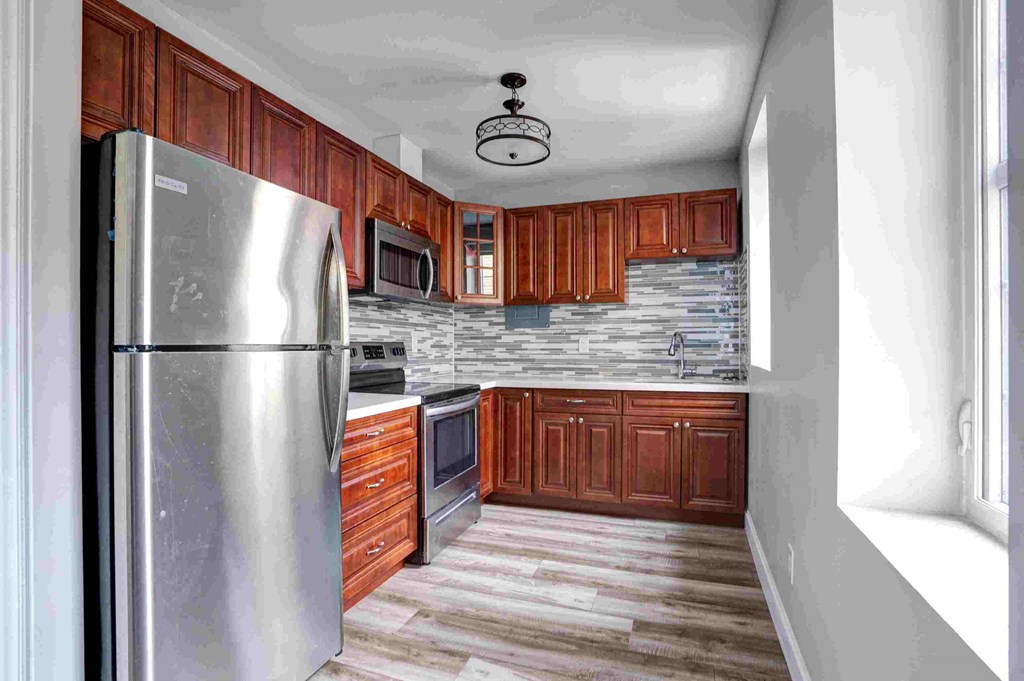 a kitchen with wooden cabinets and stainless steel appliances