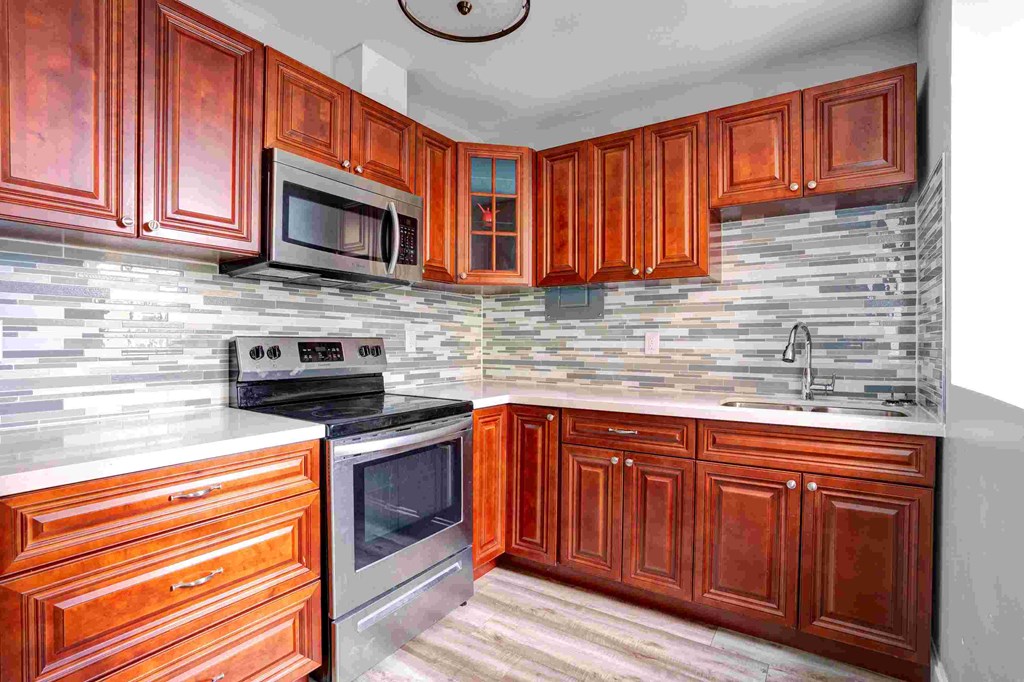 a kitchen with wooden cabinets and stainless steel appliances