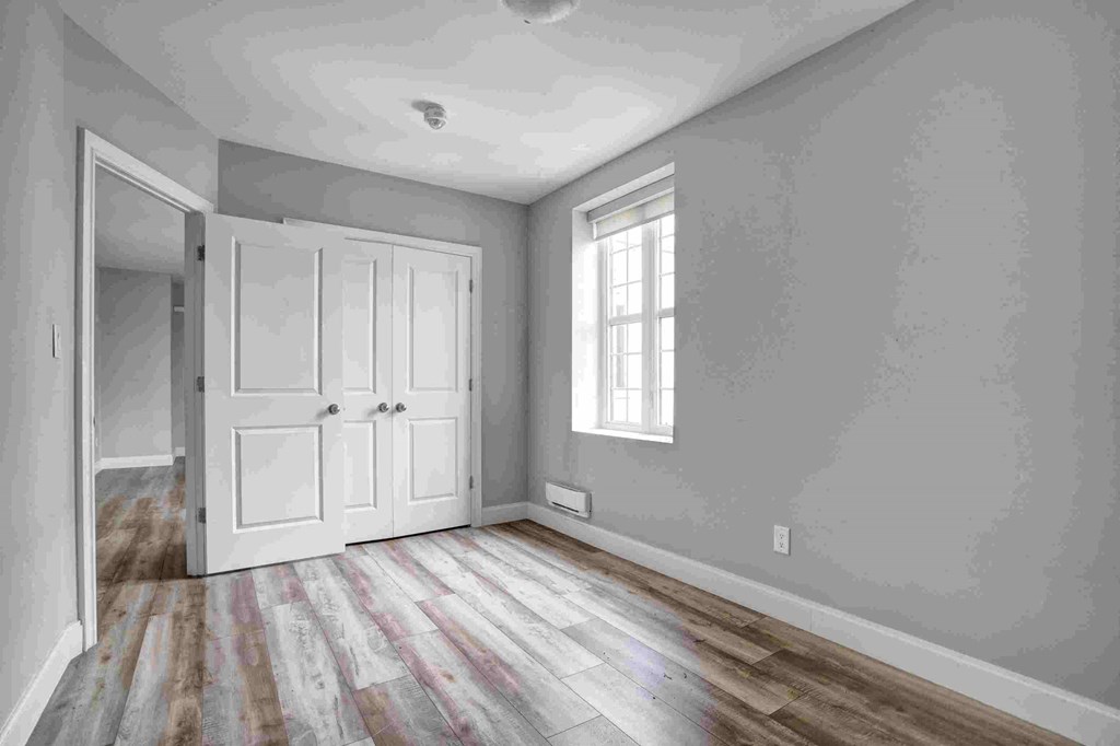 an empty room with grey walls and a white door