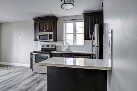 an empty kitchen with a counter top and a refrigerator