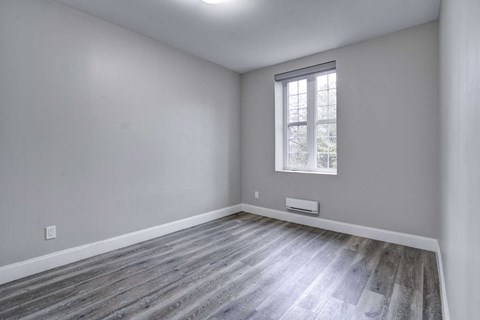 an empty room with white walls and a window