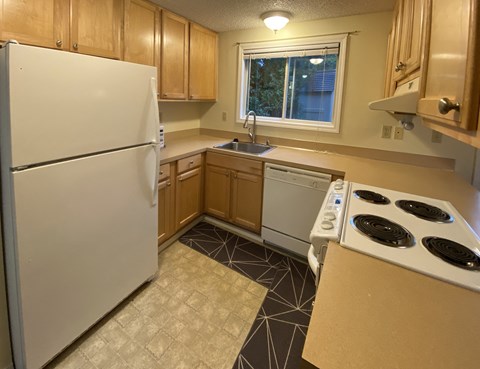 a kitchen with white appliances and wooden cabinets