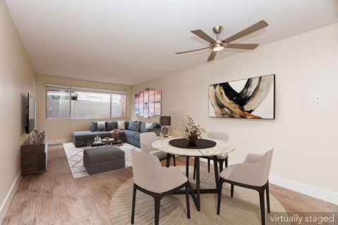 A living room with a grey couch and a white table.