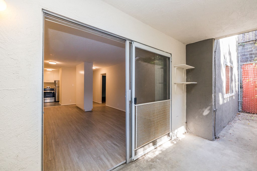 a sliding glass door leading to a living room and a kitchen