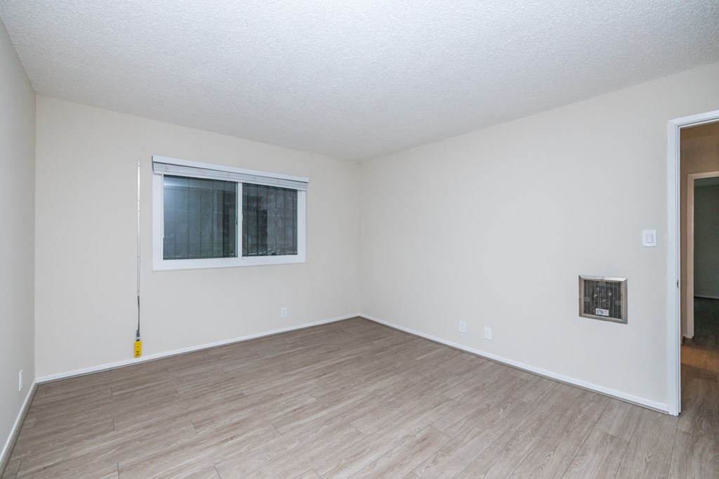an empty living room with white walls and a window
