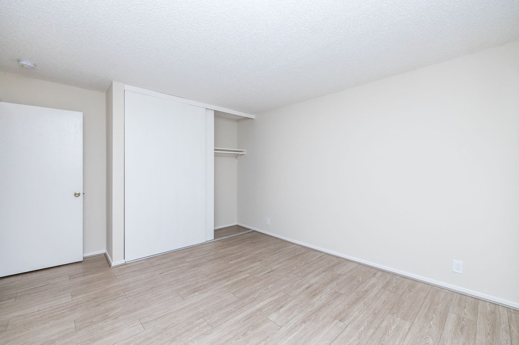 an empty living room with white walls and wood flooring