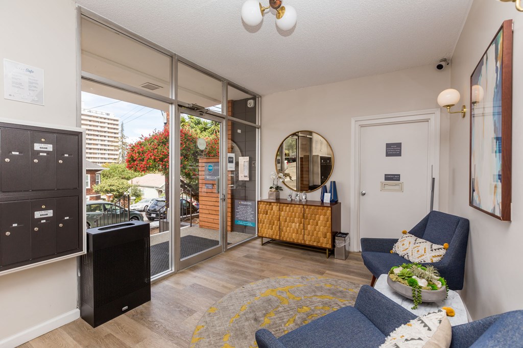 a living room with blue couches and a tv and a door to a balcony