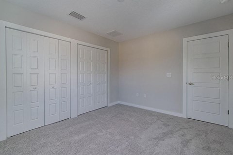 a bedroom with two closets and two doors