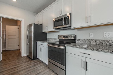 a kitchen with stainless steel appliances and white cabinets