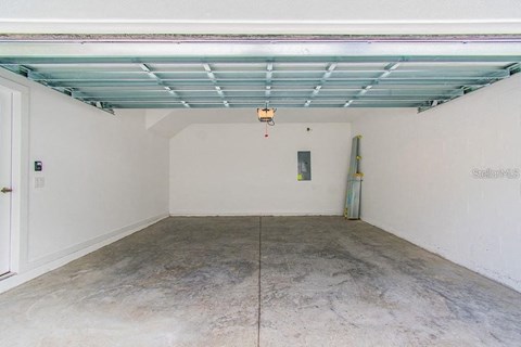 a garage with a concrete floor and a blue ceiling