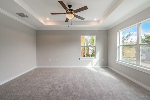 an empty living room with a ceiling fan and a window