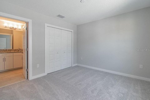 an empty living room with a door to the bathroom