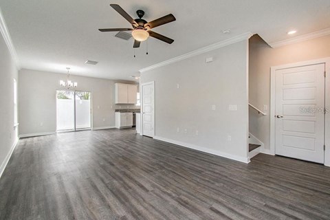 an empty living room with a ceiling fan