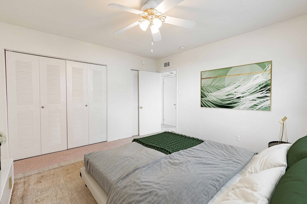 a bedroom with a bed and a ceiling fan