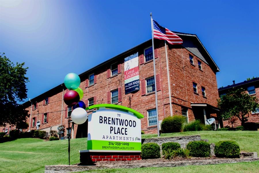 a sign in front of a brick building with an flag