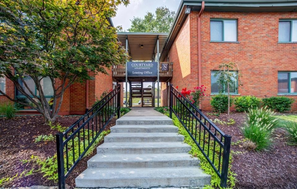 stairs in front of a brick building with a blue sign