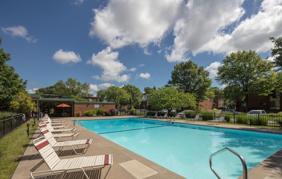 a swimming pool with white chairs around it