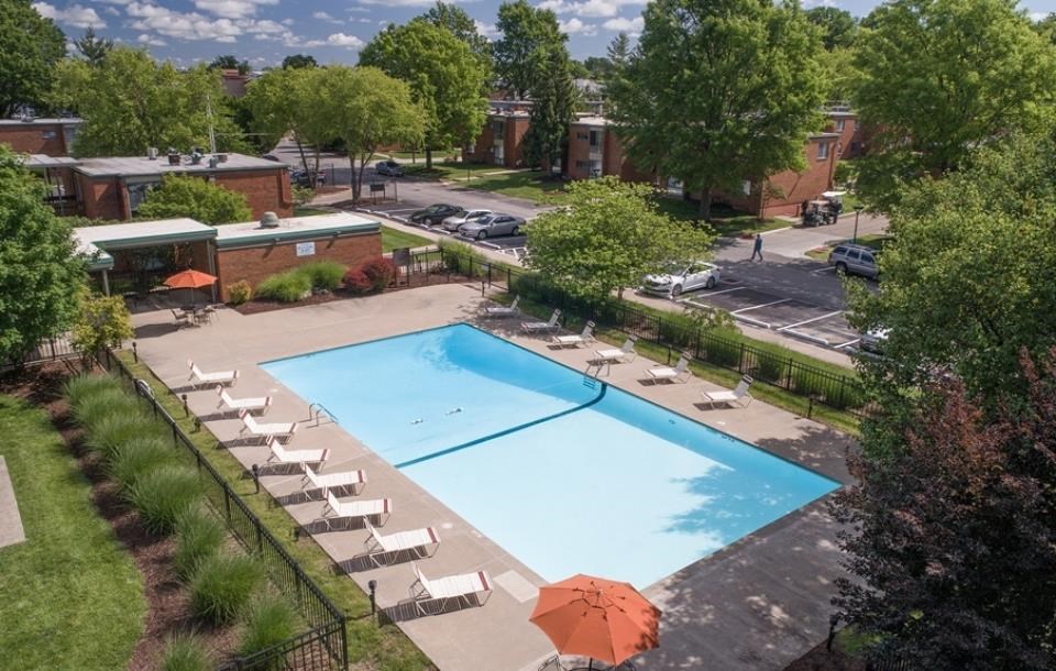 an aerial view of a swimming pool with chairs and umbrellas