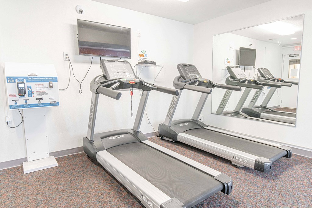 two treadmills and a television in a gym room