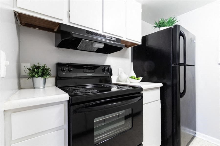 a small kitchen with a black stove and a black refrigerator