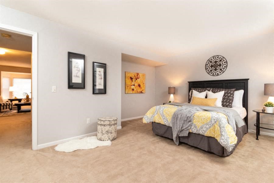 a bedroom with a bed and a door to a living room