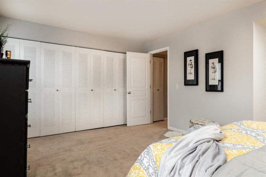 a bedroom with white closet doors and a bed