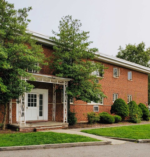 the front of a brick building with a white door