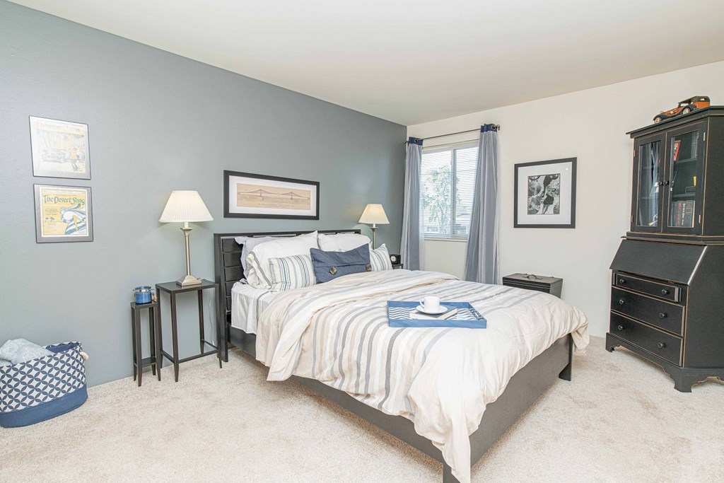 a bedroom with a bed and a dresser and a window