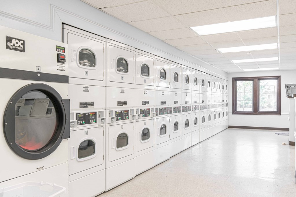 a row of washers and dryers in a laundry room