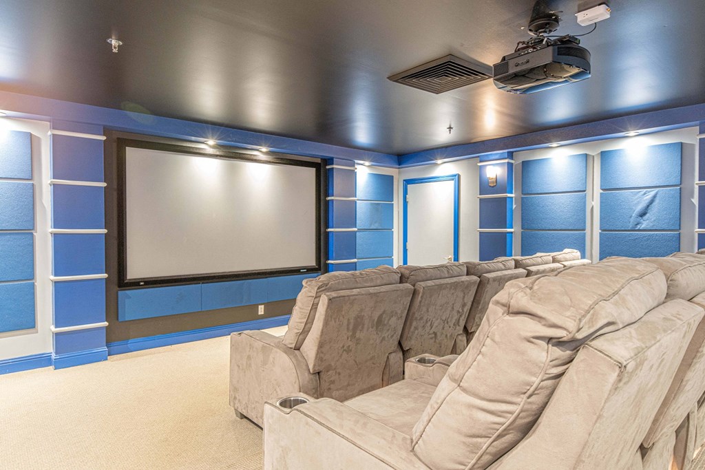 a large screening room with a large screen tv and chairs