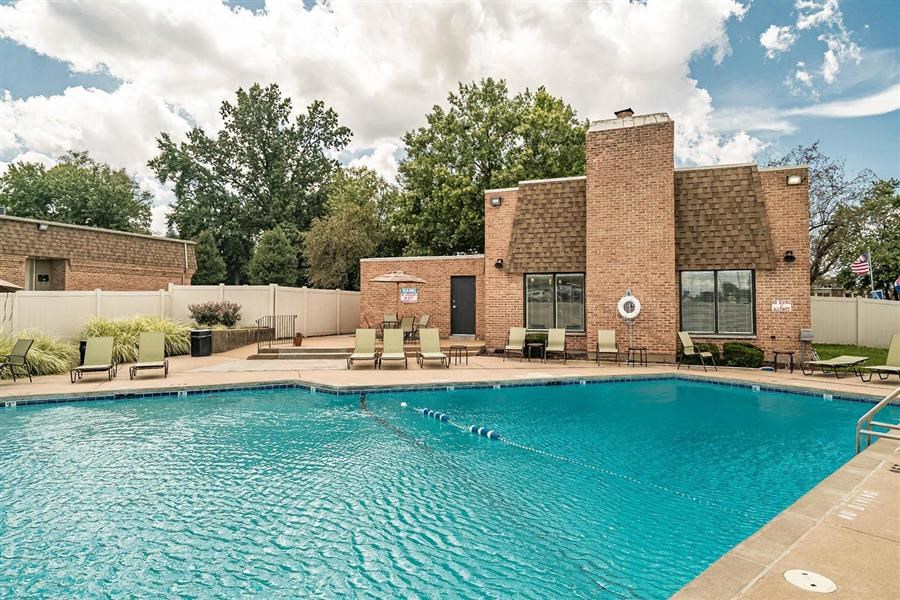 a swimming pool in front of a brick building