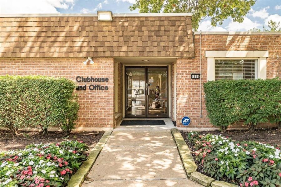 the front of a brick building with a sidewalk and a door