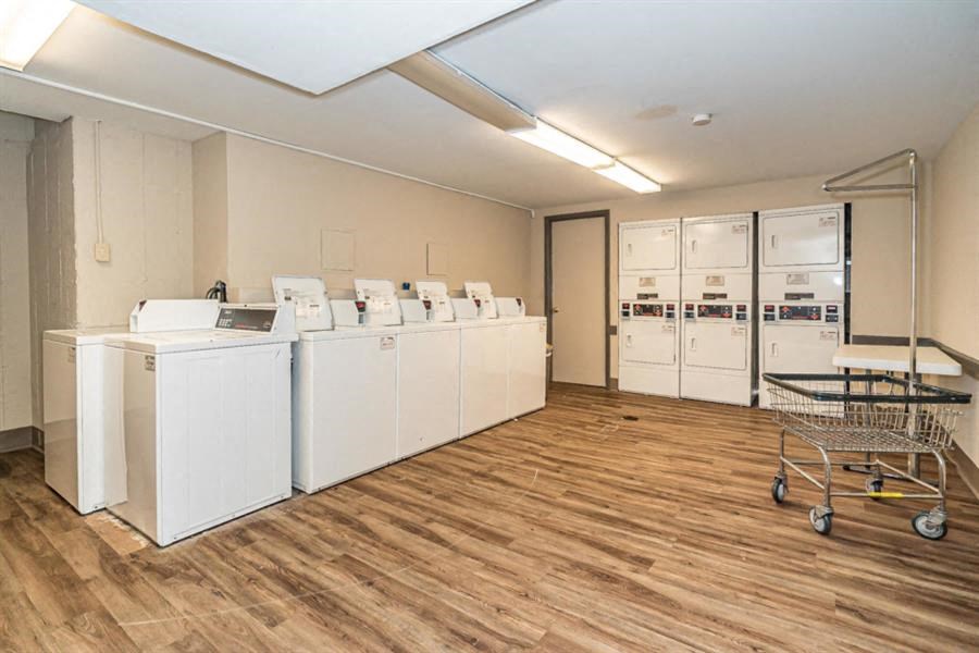 a laundry room with washes and dryers and a cart