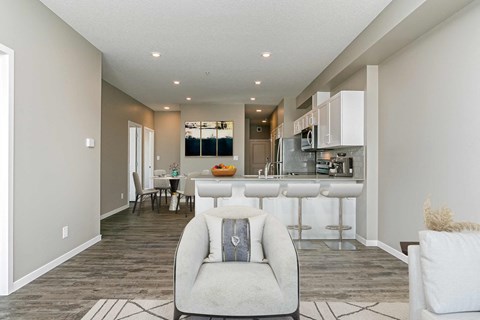 an open kitchen and living room with a white chair