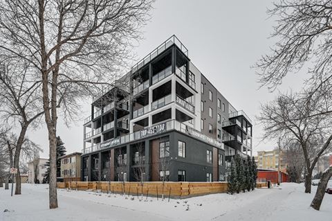 a black and white apartment building in the snow